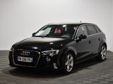 Une Audi noire est garée dans une pièce au sol carrelé en damier.