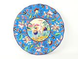 blue plate with a picture of a crane and flowers on it