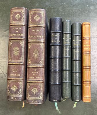 cinq vieux livres sont alignés sur une table