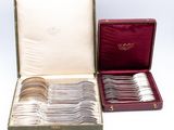 an assortment of silverware in a case on a white surface