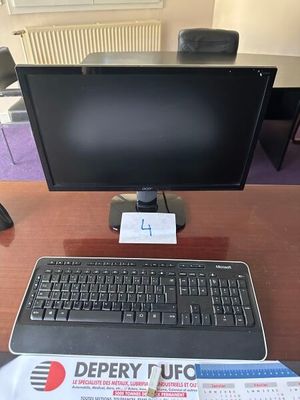 un écran d'ordinateur et un clavier sur un bureau dans une pièce