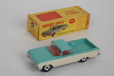 une petite voiture et une boîte posées sur une surface blanche