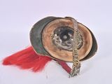 a helmet with a red feather on it on a white surface