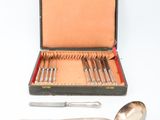 a silverware set in a case with a spoon and spoon rest