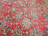 an oriental rug with red and blue colors on a wooden floor