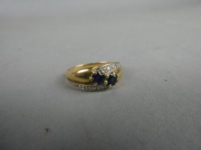 un gros plan d'une bague en or sertie d'un saphir et de diamants