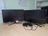 two computer monitors sitting on a desk next to each other