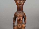 a wooden statue of a woman holding a baby in her arms