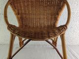 a wicker chair that is sitting on a white sheet