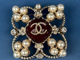 a close up of a brooch with pearls and pearls