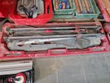 une boîte à outils rouge avec des outils sur le sol
