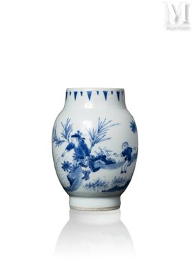 un vase bleu et blanc posé sur une surface blanche