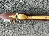 an old rifle with a wooden handle and brass fittings