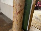 a marble column in the corner of a room