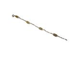 gros plan d'un bracelet en or sur fond blanc