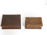 pair of antique wooden boxes with carved designs on them on a white surface