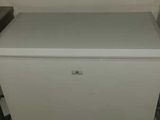 a small white refrigerator in the corner of a room