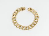 gros plan d'un bracelet en chaîne en or sur fond blanc