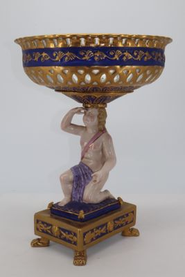 un vase bleu et or posé sur un socle, orné d'un homme