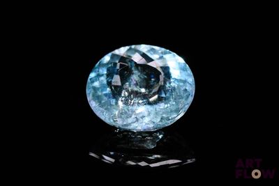 a close up of a blue diamond on a black surface