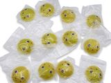 de nombreux smileys jaunes dans des sacs en plastique posés sur une surface blanche