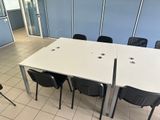 a white table with four black chairs in a room