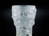 un gros plan d'un vase en verre dépoli posé sur une surface noire