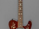 une image représentant une guitare rouge avec un motif doré sur le manche
