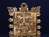 a close up of a gold pendant on a blue background
