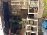 a ladder leaning up against a brick wall next to a trash can