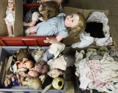 a lot of dolls in a box on the floor