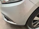 a close up of a car ' s front bumper with a denting on it