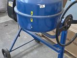 a blue cement mixer sitting on a cart in front of a pile of bags