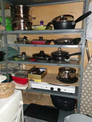 de nombreuses casseroles et poêles sur les étagères de la cuisine