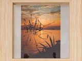 tableau représentant un coucher de soleil, avec un bateau sur l'eau et une personne debout dans l'eau