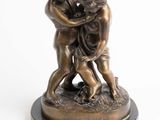 statue en bronze représentant deux enfants jouant ensemble, posée sur un socle en marbre