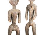 une paire de figurines en bois représentant un homme et une femme debout l'un à côté de l'autre