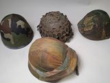 several military helmets are lined up on a white surface