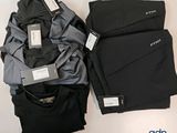 Deux paires de pantalons et une chemise sont posés sur une table