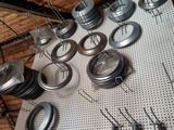 many different types of metal parts on a pegboard