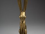 a gold statue of a rabbit sitting on top of a table