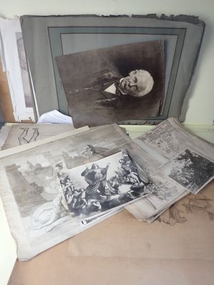 de nombreuses vieilles photos posées sur une table, avec la photo d'un homme