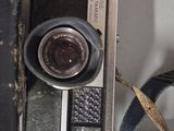 an old camera sitting on a table next to a bag