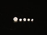 a group of three white diamonds sitting on top of a black surface