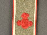 un insigne d'uniforme militaire représentant une fleur rouge sur fond gris