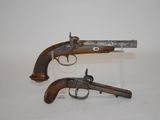 two old guns are on display on a white surface