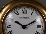 a gold clock with roman numerals on the face