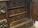 a wooden cabinet with carvings on the top of it