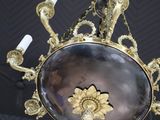 a chandelier that has a mirror in the middle of it