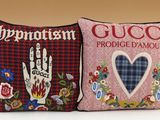 two pillows with embroidered designs on them are sitting on a table